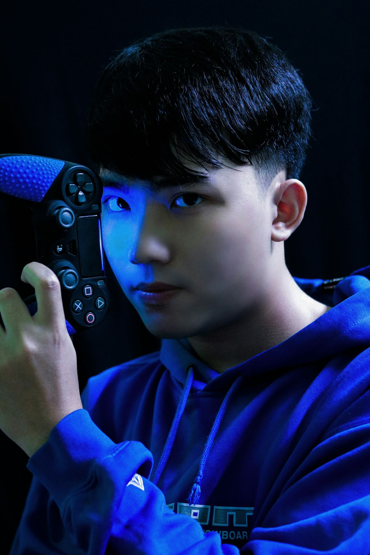boy in blue long sleeve shirt holding black game controller